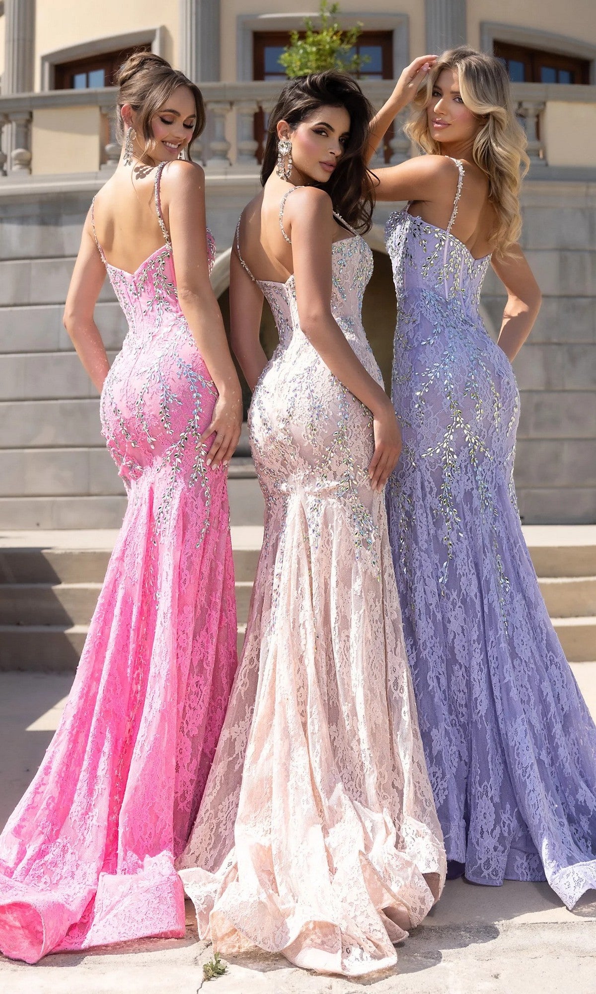 Three women stand outdoors with their backs to the camera, wearing Portia and Scarlett PS25150 long prom dresses in pink, beige, and lavender, featuring fitted lace mermaid silhouettes, sequin embellishments, thin straps, and elegant crystal beading.